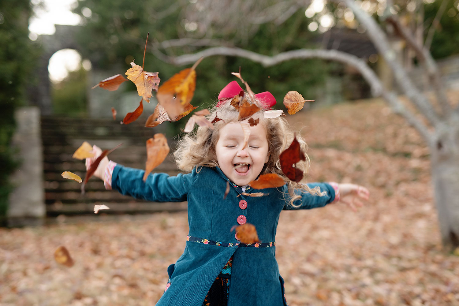 girl tossing leaves